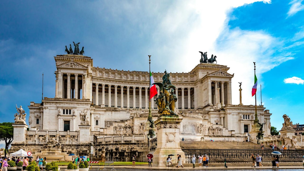 Stunning view of the Vittoriano Monument in Rome's Piazza Venezia with Italian flags and statues.
