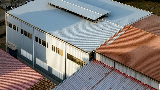 Aerial shot showcasing industrial building roofs with varying colors in Luoyang, China.