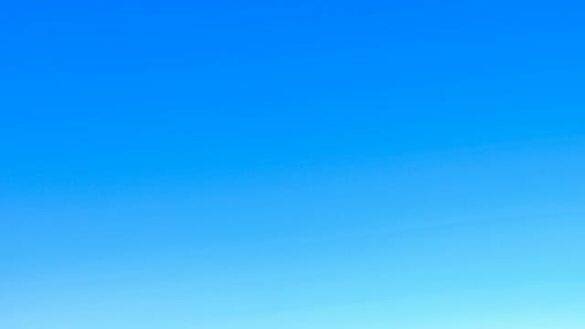 A serene view of a vibrant clear blue sky with a subtle gradient, perfect for backgrounds.