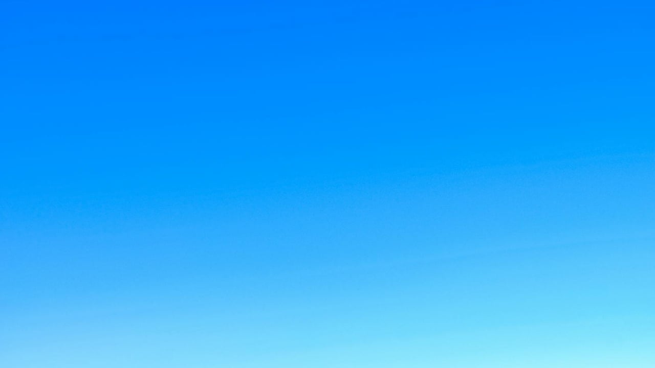 A serene view of a vibrant clear blue sky with a subtle gradient, perfect for backgrounds.