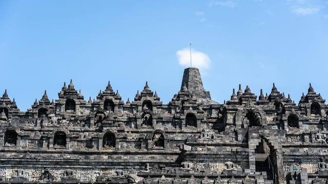 Close-up of Borobudur Temple showcasing its intricate architecture against a clear blue sky.