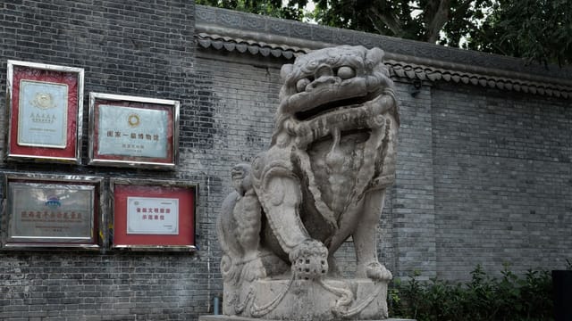 A detailed view of a traditional Chinese stone lion statue in Xi'an, Shaanxi Province.