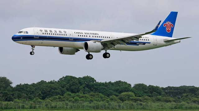 China Southern Airlines Airbus A321 aircraft landing on a clear day.