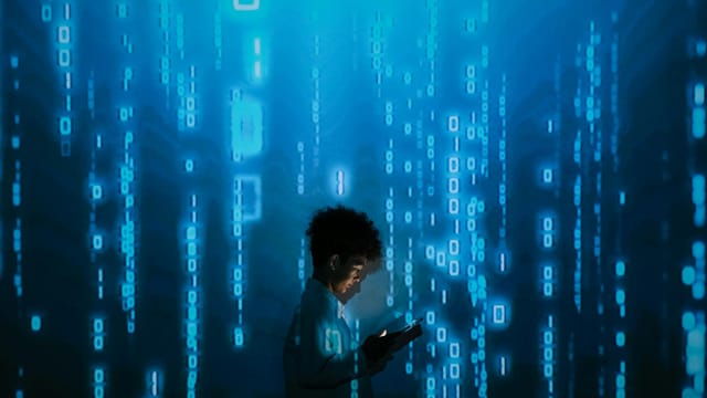 Silhouette of a person using a smartphone surrounded by digital binary code projections.