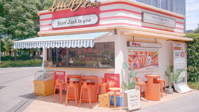 Charming outdoor food booth with retro design offering burgers and drinks.