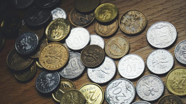 Close-up view of various Polish coins on a wooden table showcasing currency and finance concepts.