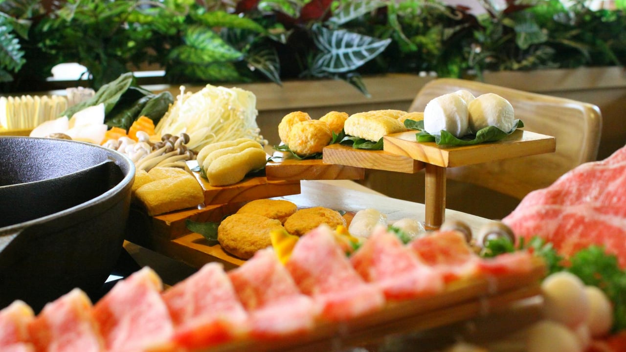A delightful Cambodian table setting featuring hot pot ingredients and a variety of local delicacies in Phnom Penh.