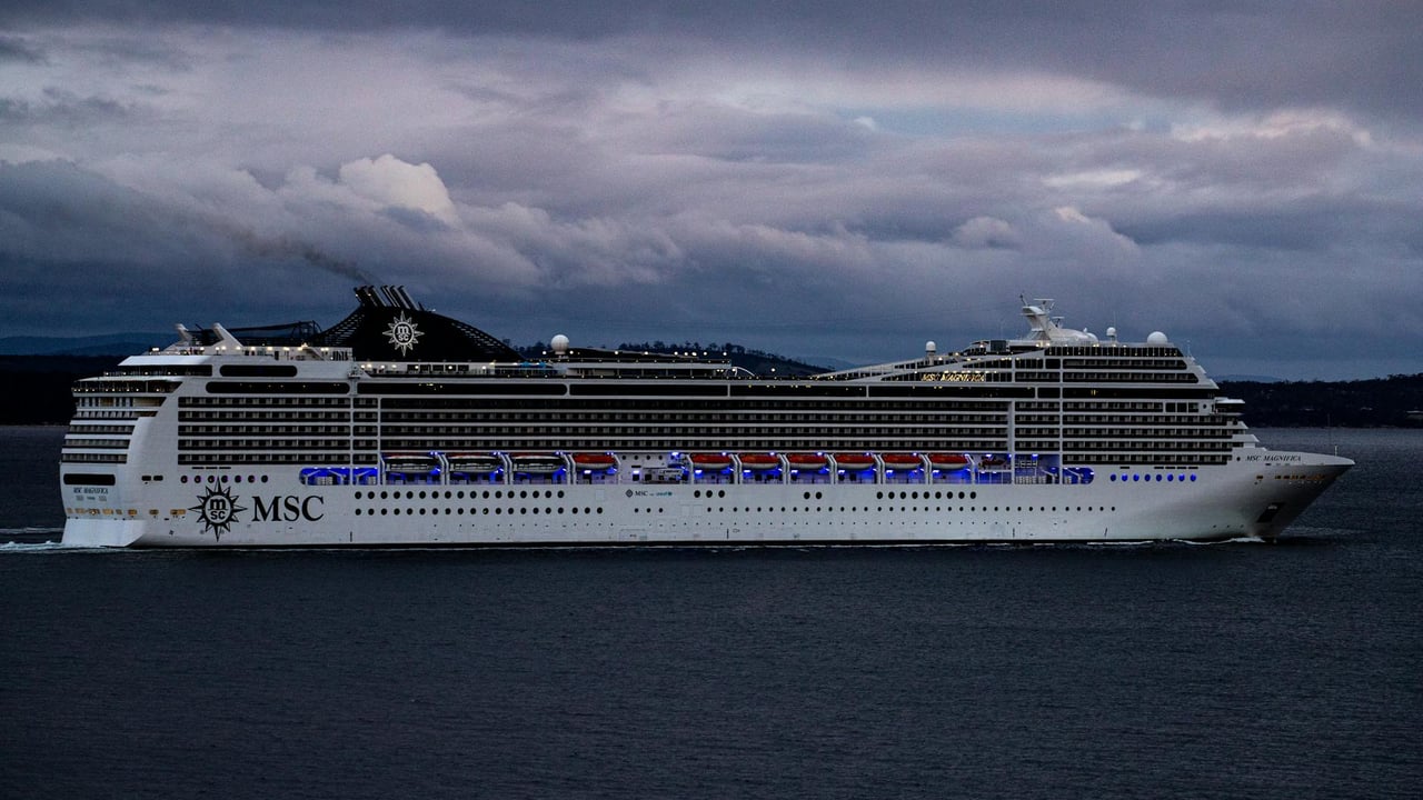 MSC cruise ship navigating waters near Hobart, Tasmania against a dramatic cloudy sky.