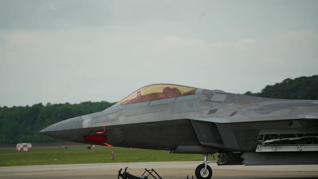 A US Air Force fighter jet stationed on a runway at Langley, Virginia, ready for takeoff.