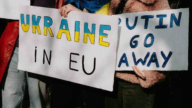 Protest with signs supporting Ukraine in EU and opposing Putin. Capturing a social movement outdoors.