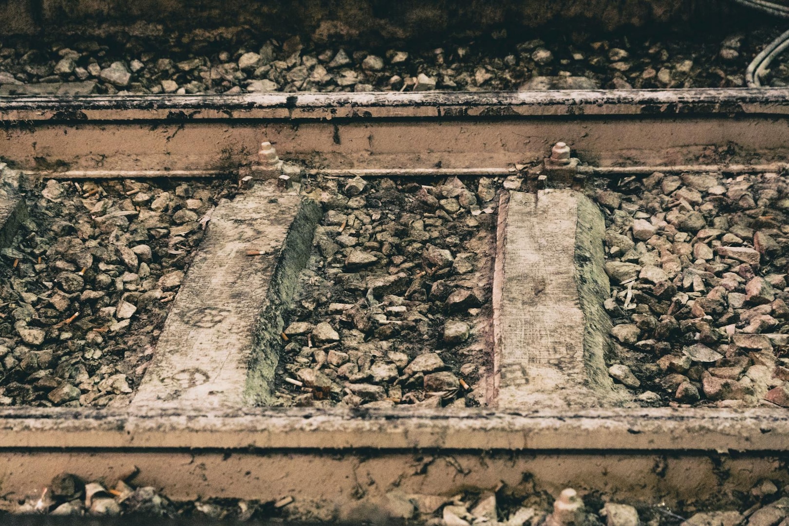 Detailed view of Milano railway tracks with rocks and concrete sleepers.