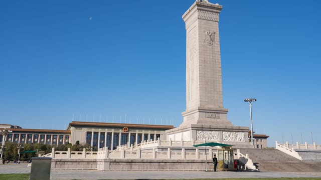 Monument to the People's Heroes in Tiananmen Square, Beijing, China, under a clear blue sky.