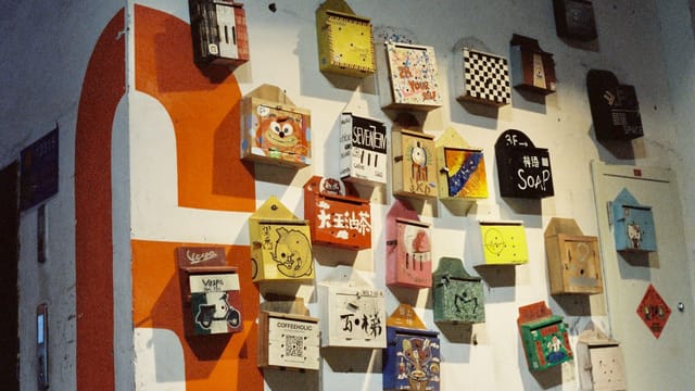 Vibrant decorated boxes creatively displayed on a wall with artistic flair.