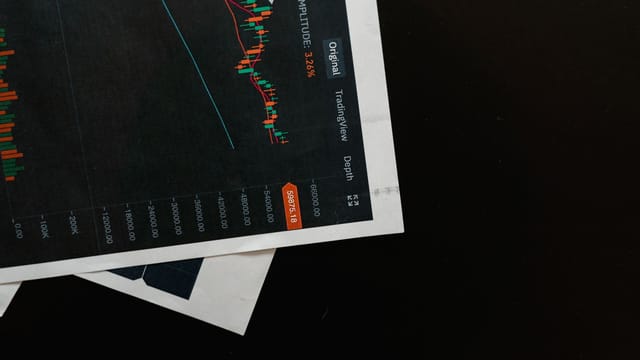 Detailed close-up of a financial chart on a black surface, showing stock market analysis.