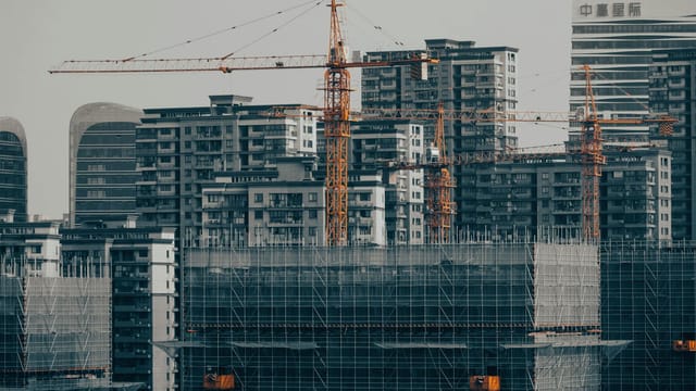 A view of a city under development with cranes and skyscrapers showcasing urban growth.