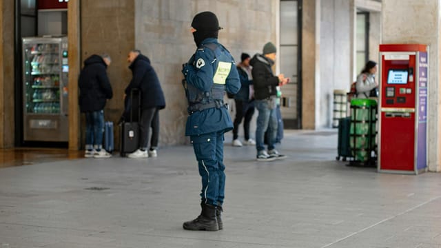 Security personnel on duty at a busy train station in Florence, Italy.