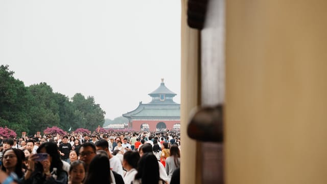 A bustling crowd at the iconic Temple of Heaven in Beijing, China.