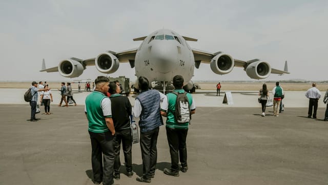 A Boeing C-17 military aircraft displayed at an airfield event with people observing.