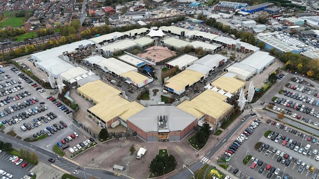 Explore the sprawling layout of Junction 32 Shopping Centre from an aerial perspective in West Yorkshire, England.