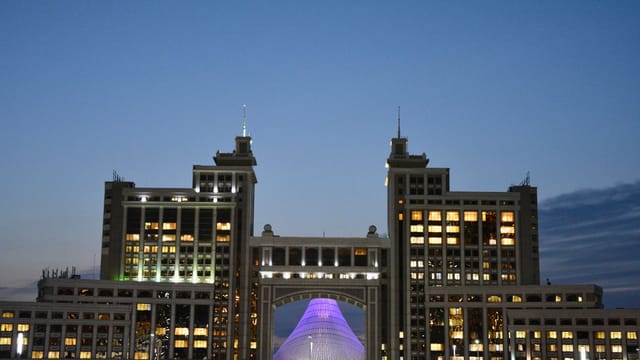 Majestic view of Astana's iconic architecture glowing against evening sky.