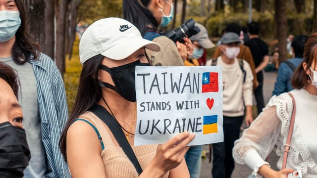 A street protest in Taiwan showing solidarity with Ukraine amidst a diverse crowd.