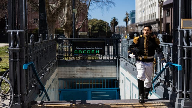 Man in historical uniform exiting subway in Buenos Aires, Argentina, on a sunny day.