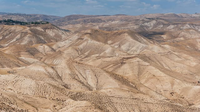 Scenic view of arid desert hills under a clear blue sky in Israel.