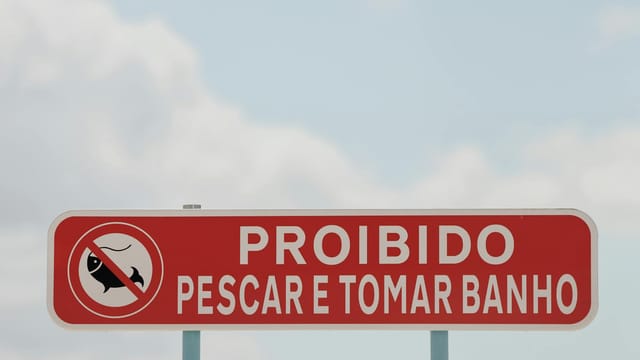 Red prohibition sign in Lisbon, Portugal forbidding fishing and bathing.