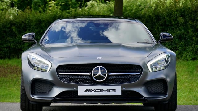 Front view of a luxury Mercedes-Benz AMG against a natural backdrop.
