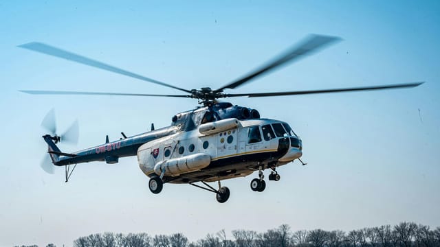 Dynamic shot of a helicopter in mid-flight over a field in Nitra, Slovakia.