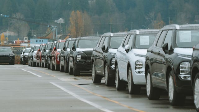A line of new SUVs parked in an outdoor dealership lot, ready for sale.