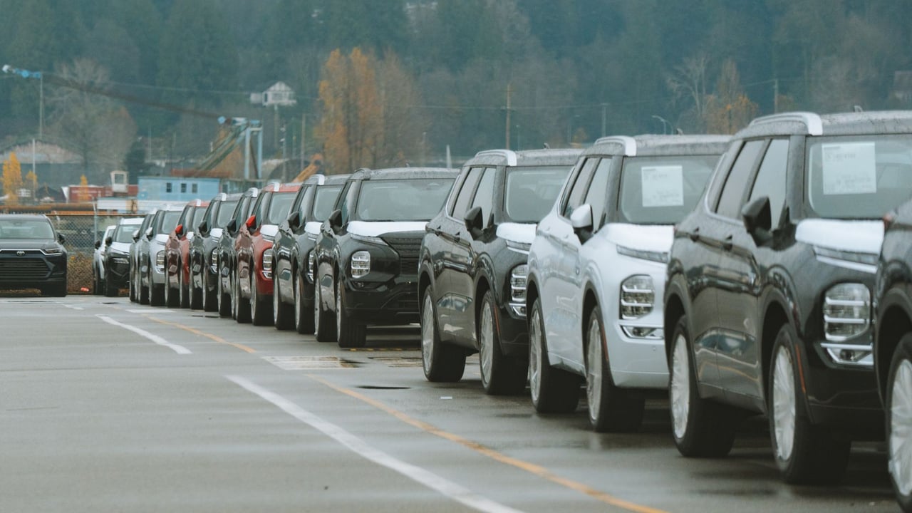 A line of new SUVs parked in an outdoor dealership lot, ready for sale.