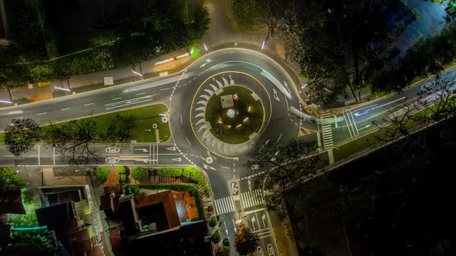 High-angle shot of a brightly lit roundabout in Colombia at night.