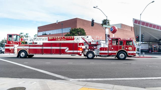Beverly Hills fire truck driving through a city street, showcasing emergency services in action.