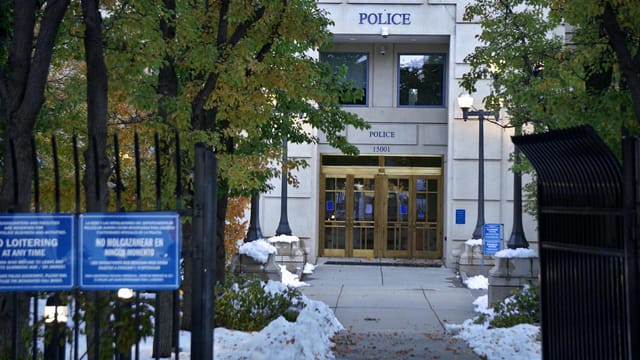 Police station entrance with snow on the ground and no loitering signs.