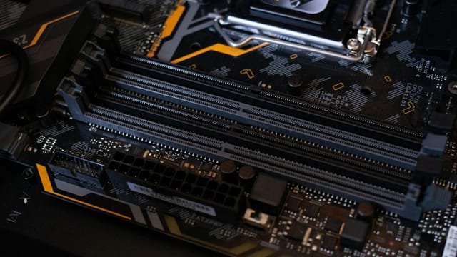 Detailed view of a computer motherboard showcasing RAM slots and electronic components.