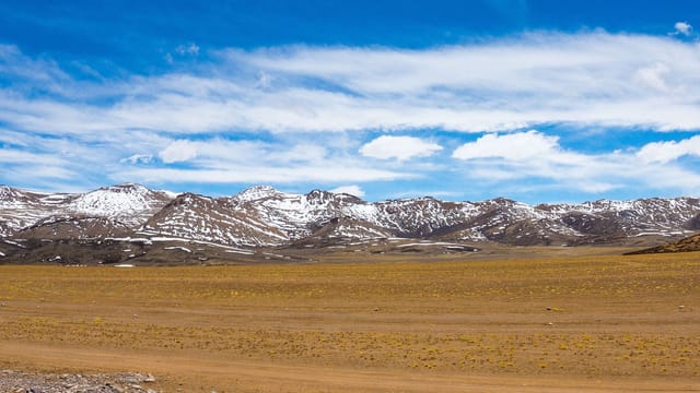 Beautiful snow-capped mountains under a clear blue sky in Ngari, Tibet.
