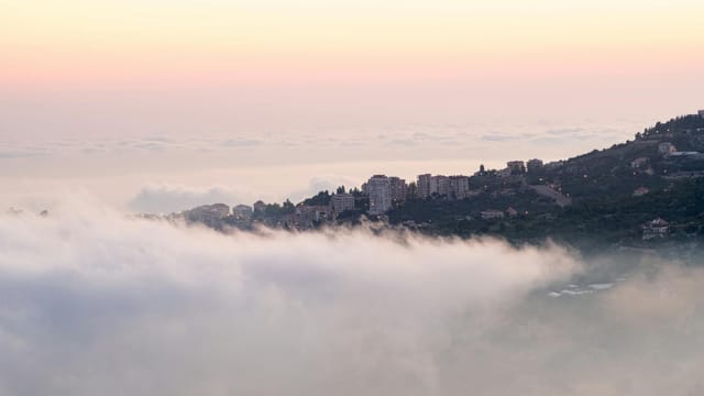 Scenic view of Faraiya's landscape with misty clouds at sunrise in Lebanon.