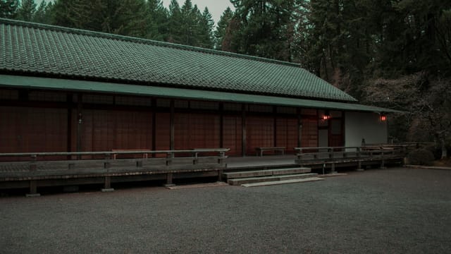 A peaceful Japanese-style building surrounded by lush trees in Portland, Oregon creates a serene atmosphere.