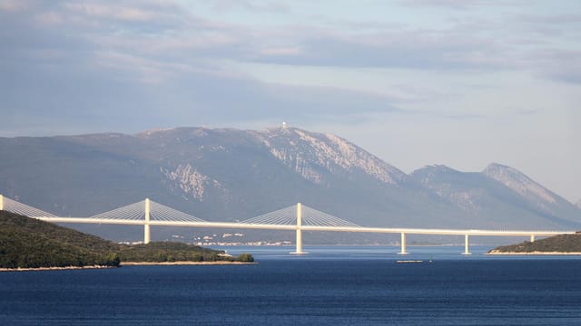 Breathtaking view of Pelješac Bridge with mountains and sea, captured in Neum, Bosnia and Herzegovina.
