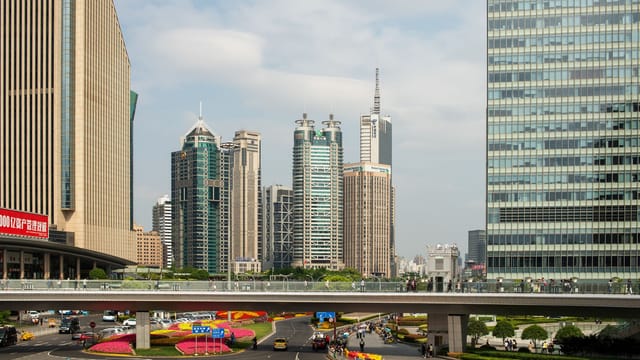 Panoramic view of Shanghai's Lujiazui skyline featuring modern skyscrapers, overpass, and vibrant city life.