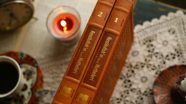 Warm and inviting reading nook with books and a softly glowing candle.