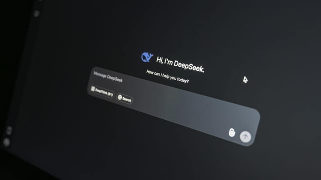 Close-up of DeepSeek AI chat interface on a laptop screen in low light.