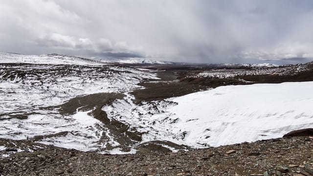 Panoramic view of snow-capped mountains and rugged terrain in Yushu, China.