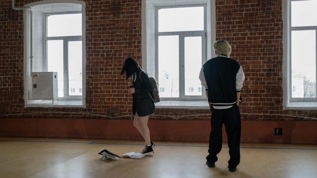A boy intimidates a girl in a school hallway, depicting a bullying scenario.