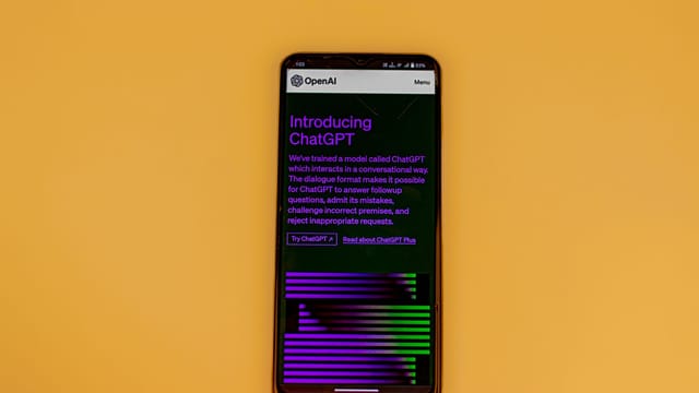 Smartphone displaying ChatGPT interface on a vibrant background, showcasing AI technology.