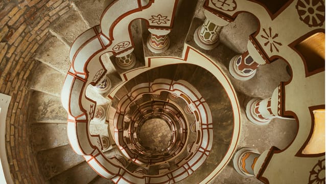 Intricate spiral staircase inside ornate Bory Castle, Hungary, showcasing unique architectural design.