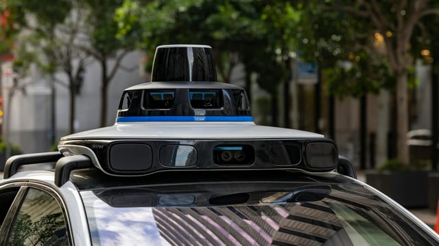 Detailed view of sensors atop an autonomous car, showcasing advanced technology in an urban setting.