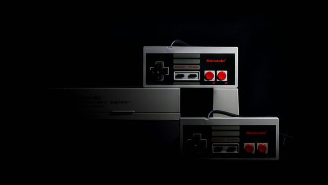 Retro gaming controllers from the Nintendo Entertainment System in low-key lighting, evoking nostalgia.