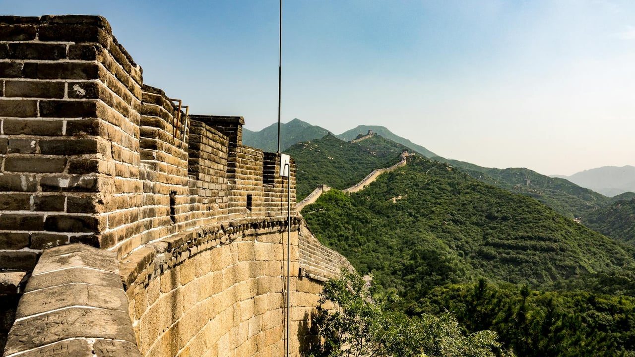 Stunning view of the Great Wall winding through lush hills under a clear sky.